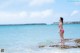 A woman in a pink bikini standing in the ocean.