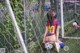 A woman sitting on the ground next to a soccer ball.