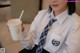 A woman in a white shirt and tie holding a cup of coffee.