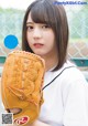 A woman in a baseball uniform holding a baseball glove.