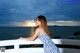 A woman in a blue and white dress standing on a balcony.