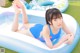 A woman in a blue swimsuit laying on an inflatable pool.