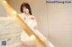 A woman in a white dress sitting on a marble staircase.